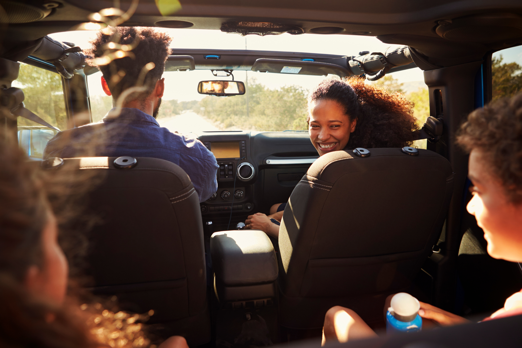 A happy family smiles at each other in the car